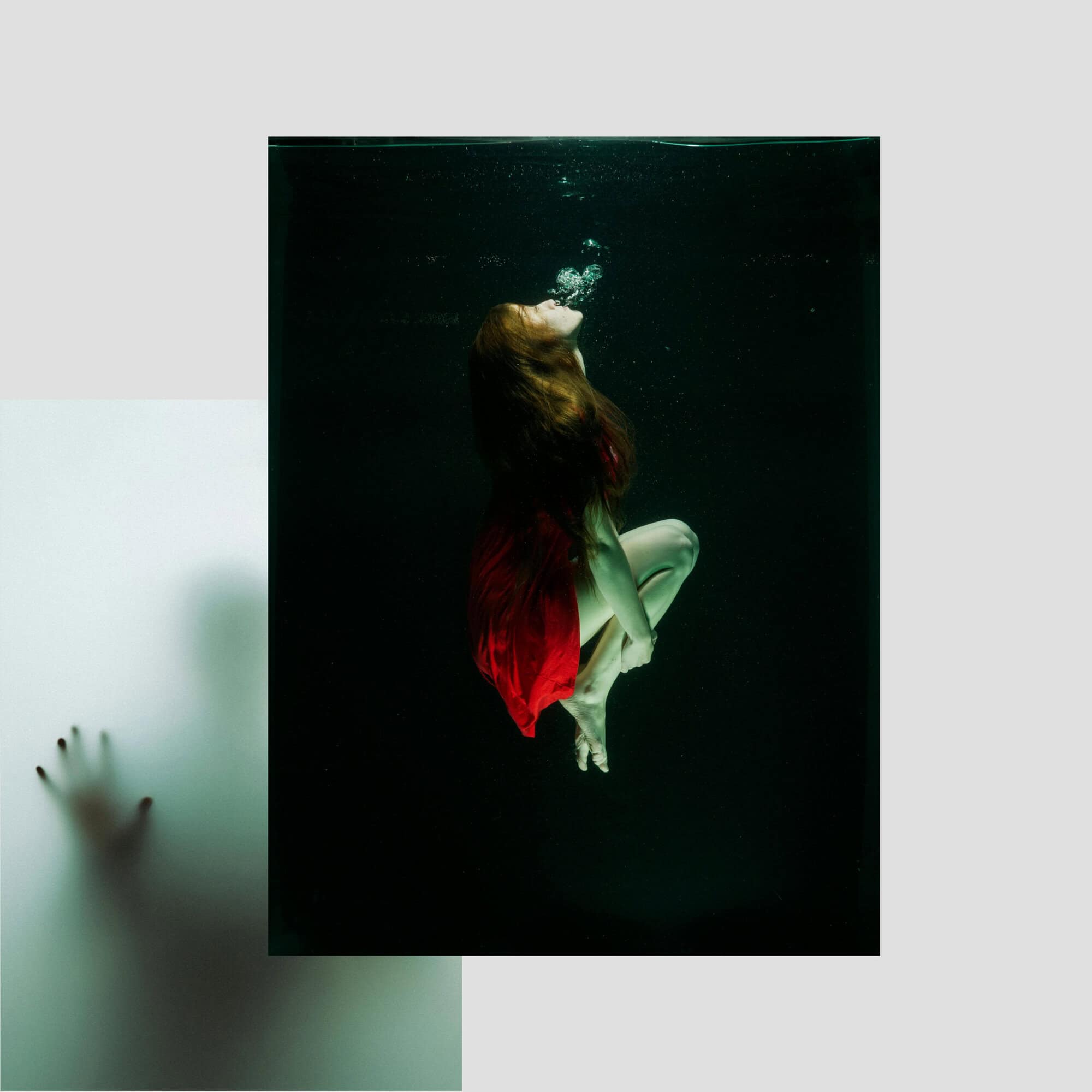 Refined red dress woman underwater, artistic photography, moody and mysterious vibe, fashion and creative concept.