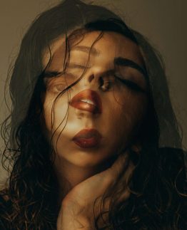 Close-up of a woman with styling inspiration, emphasizing makeup and hair.